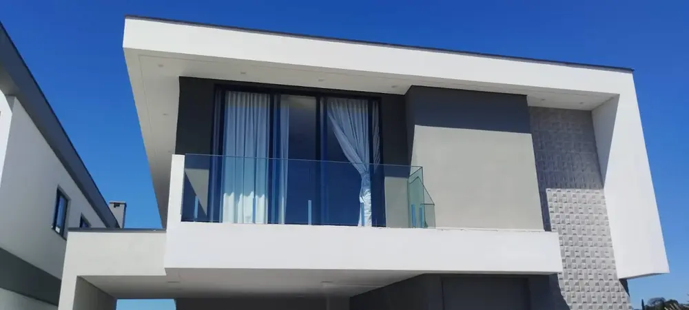 Fachada de casa com varanda de vidro